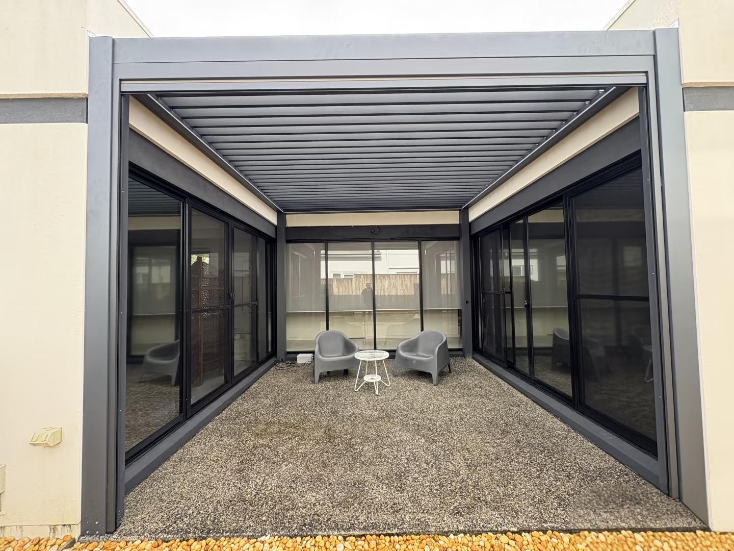 Alu180 pergola interior view with 5% light gray roller blinds